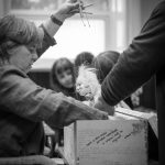 black and white photo of Corina Duyn taking puppet out of box