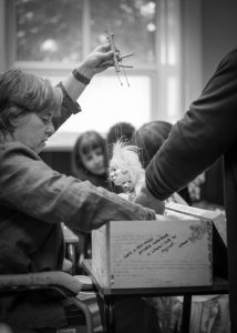 black and white photo of Corina Duyn taking puppet out of box